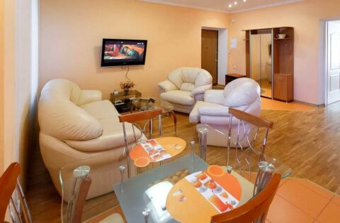 Open-plan living and dining area with glass table and leather sofas