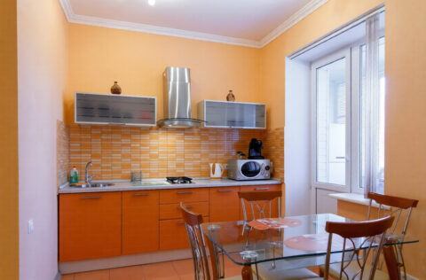 Separate kitchen with wooden cabinets, dining table and window